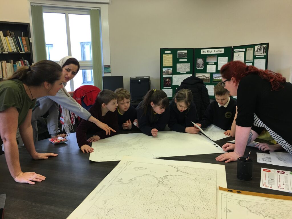 Catherine MacPhee (right) assists a local school group in the Skye and Lochalsh Archive Centre room